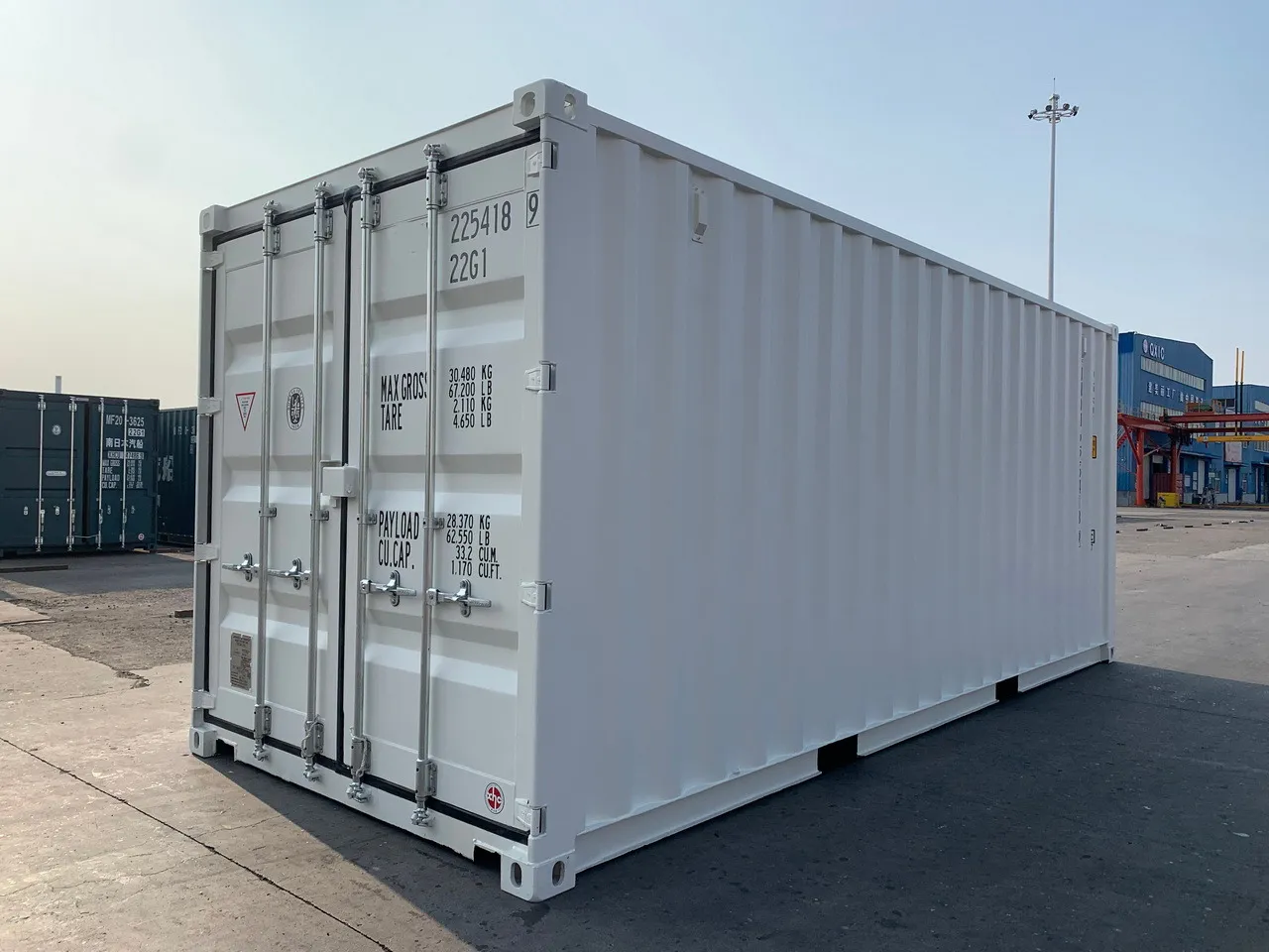 Weißer 20-Fuß-Seecontainer im Hafen, Ansicht auf die Türseite.