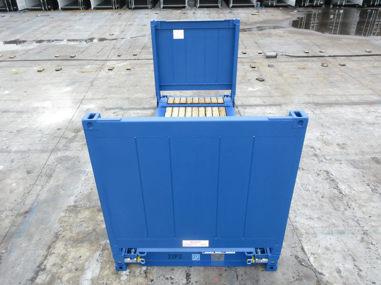 Blauer 20-Fuß Flat-Rack-Container mit klappbaren Stirnwänden und Holzboden, Frontansicht.